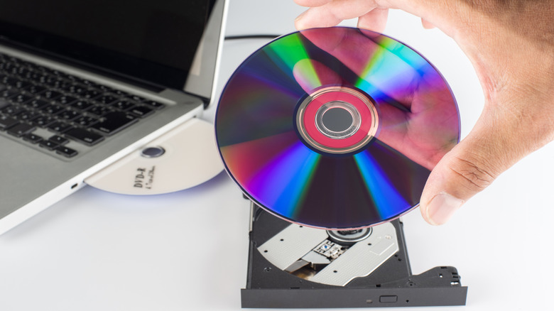 Hand inserting a DVD into an external disc drive