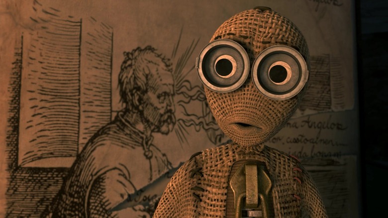 Elijah Wood's character, #9, facing the camera with a drawing of a man in the background