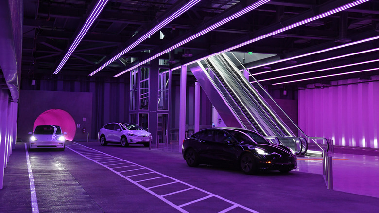 a Tesla coming out of an underground tunnel and into a parking area