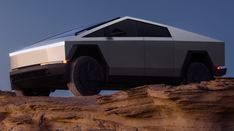 Tesla Cybertruck parked on a desert ridge with a blue sky in the background