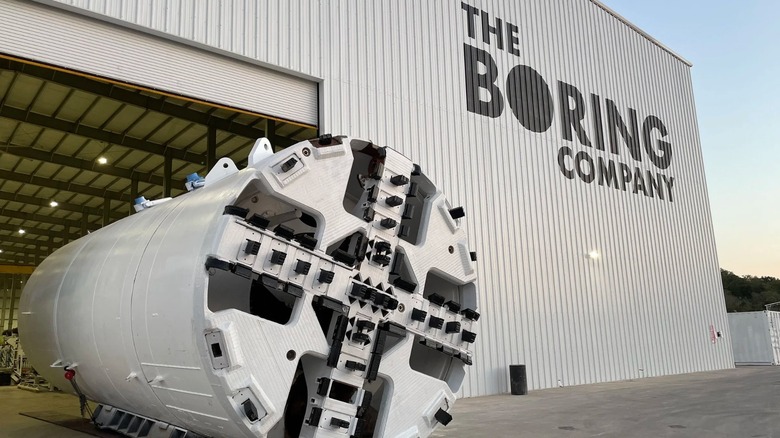 Boring Company drill parked outside of a warehouse