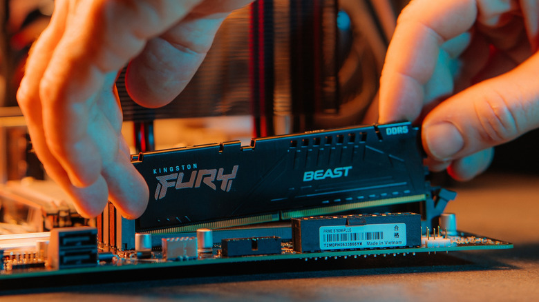 DDR5 Kingston Fury RAM being inserted into motherboard slot