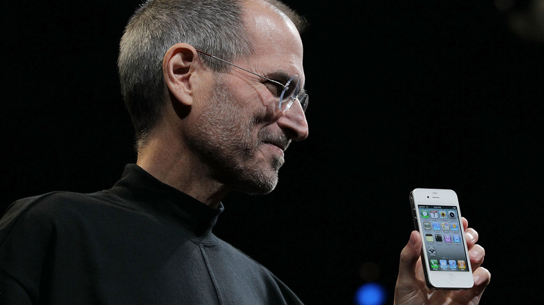 Steve Jobs holds the iPhone 4 during a keynote