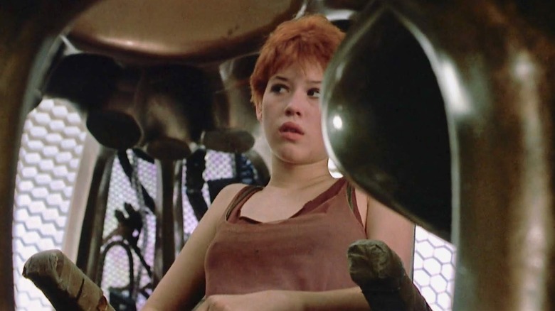 Niki (Molly Ringwald) sitting down in "Spacehunter: Adventures in the Forbidden Zone."