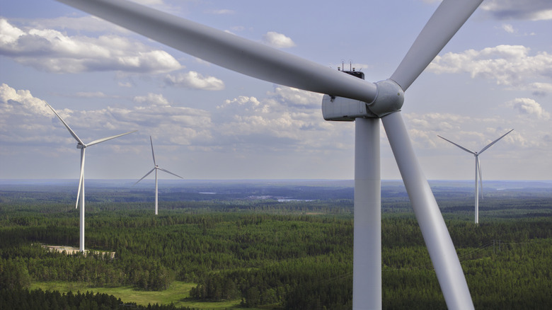 Close-up of wind turbines in a rural area with the massive blades visible.