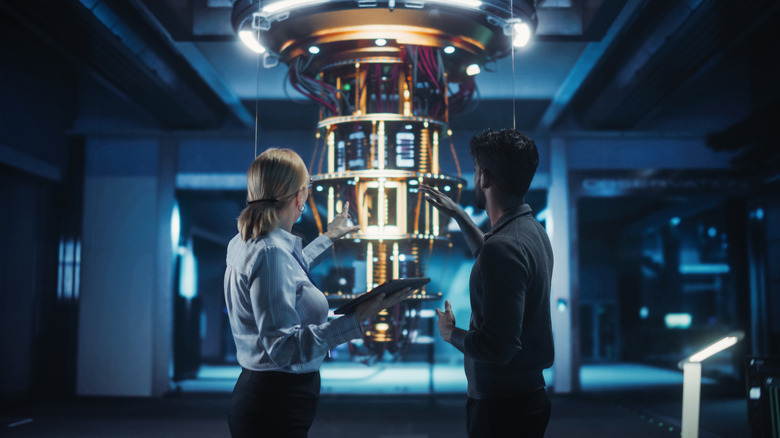 Researchers discussing a quantum computer conceptualized in the background.