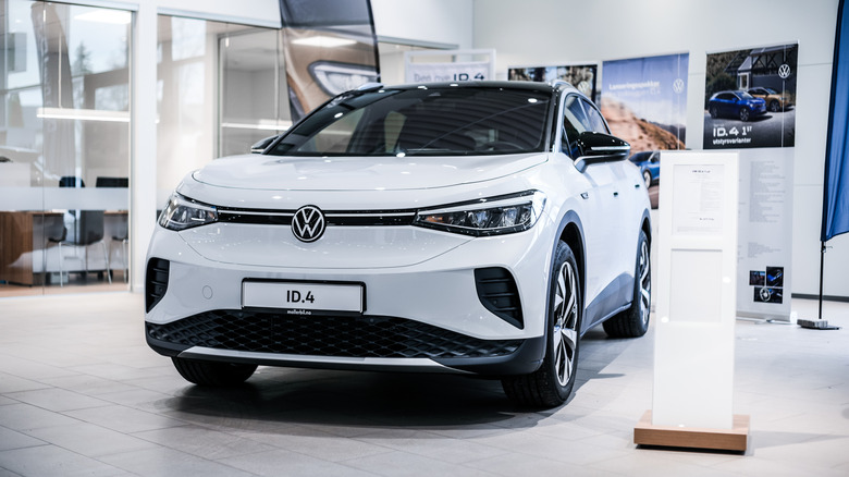 White Volkswagen ID.4 displayed inside a dealership showroom.