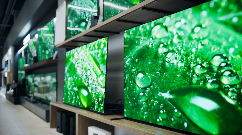 A wall of demo TVs at a retail outlet.
