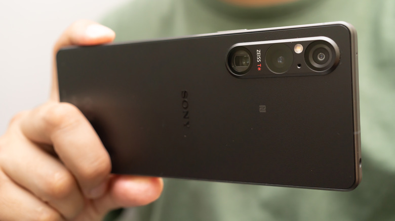 Man in green shirt holding Sony Xperia 1