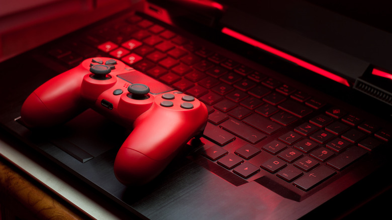 Red playstation dualshock controller on gaming laptop.