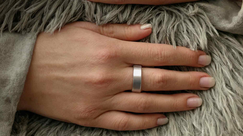Leep ring on a woman's hand, pressed against their fur coat