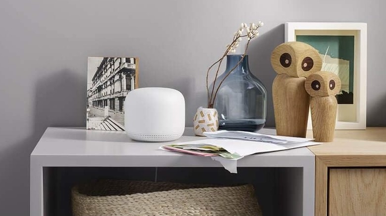 Google Nest Wi-Fi mesh unit on a table next to ornaments