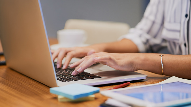 Woman's hands typing on a laptop keyboard