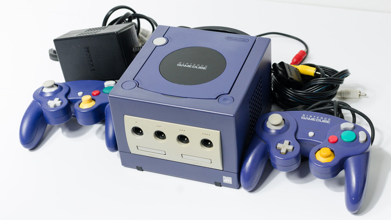 A Nintendo GameCube and two controllers next to it on a white surface