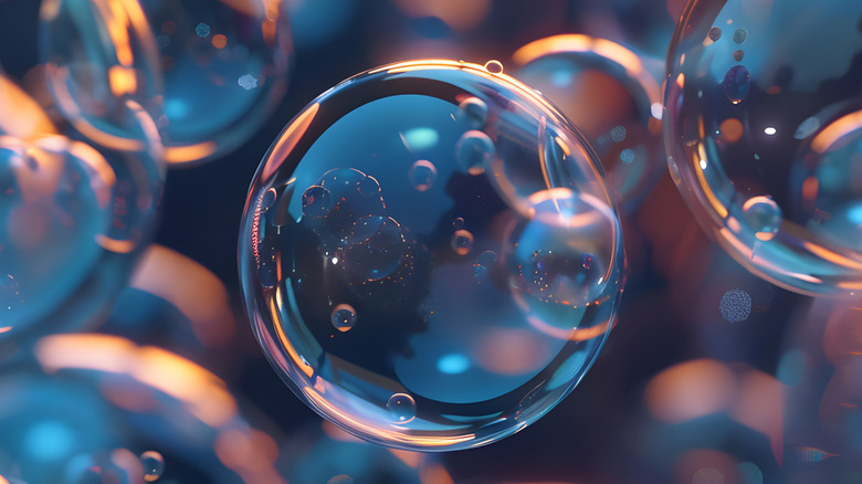 Close up view of a soap bubble surrounded by other similar ones reflecting orange and blue lights