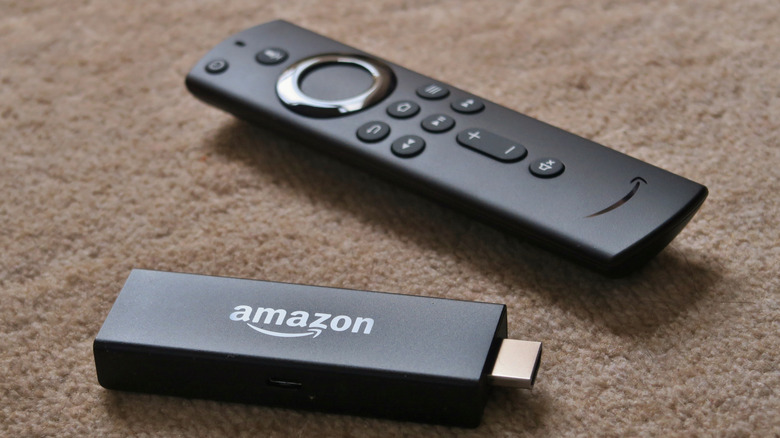 An Amazon Fire TV Stick next to its remote.