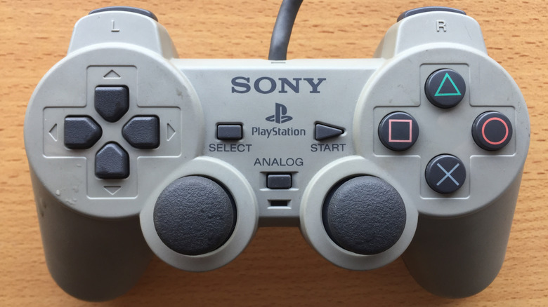 The Dual Analog PlayStation controller on a wooden surface