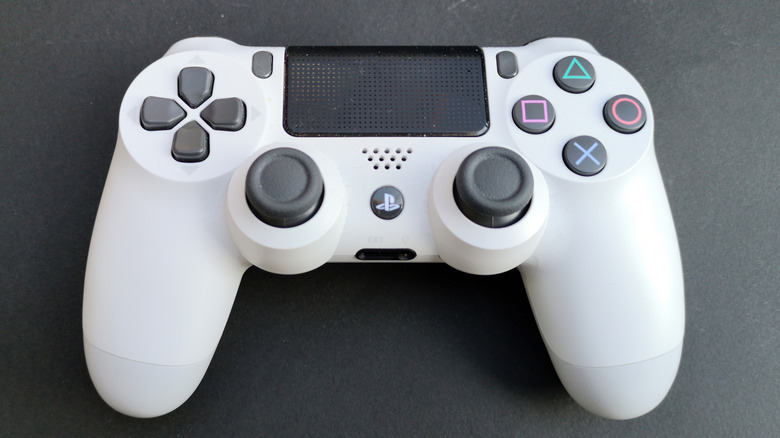 A white 2nd Generation DualShock 4 on a gray surface