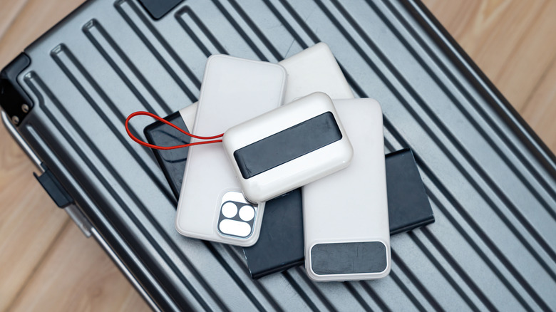 Portable chargers and travel accessories on gray suitcase