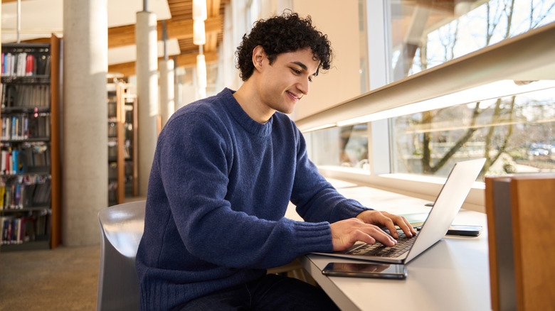 A student working on a laptop in a library