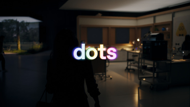 Hero image for dots, with the letters spelled out in front of a person by their computer at night