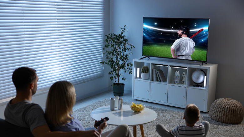 Family watching a baseball game at home.