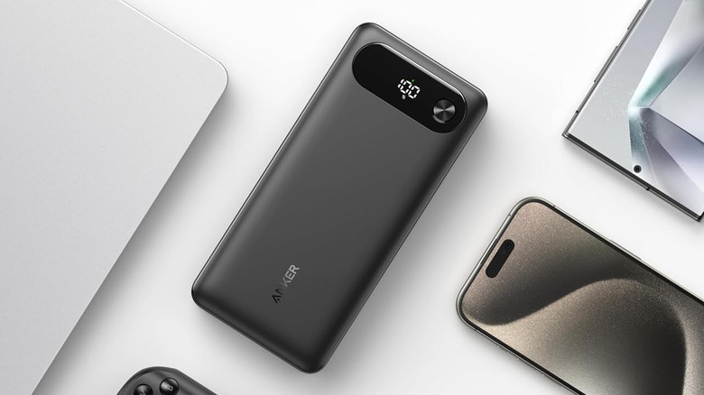 Anker Power Bank 20K with digital battery display shown beside a laptop and smartphone