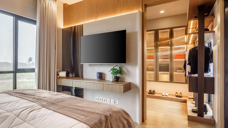 A TV mounted on the wall in a bedroom.
