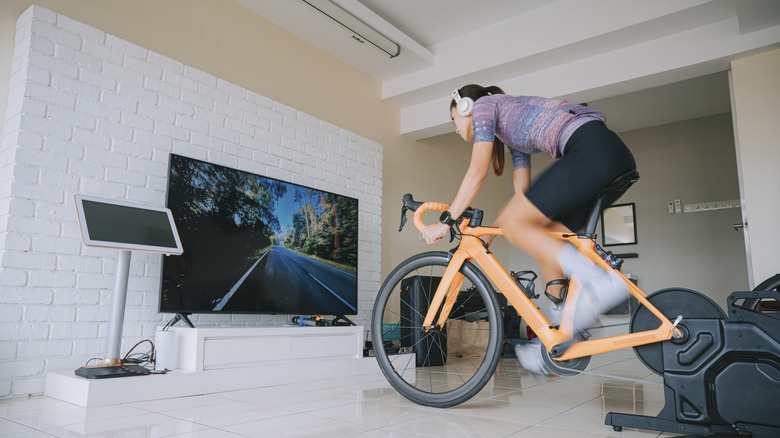 A person exercising on a bike in front of the TV.