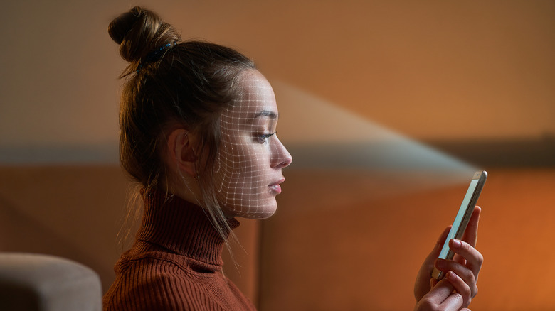 A woman's face being scanned by a phone's front camera