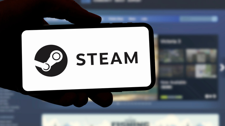 Steam logo on smartphone in front of Steam Store website in background