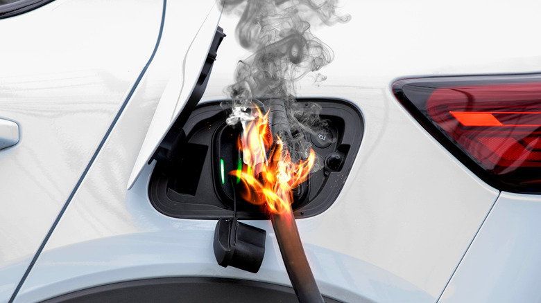 An electric car charger going up in flames while connected to a car