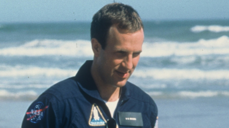 Jack Riles walking in front of the ocean in 