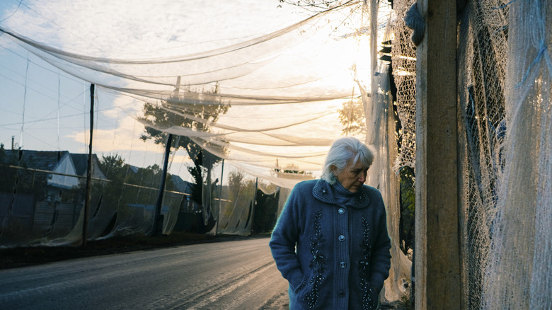 A woman walks down a street overlayed with nets