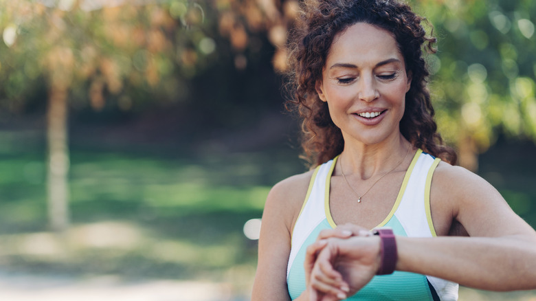 A woman checking a fitness tracker during a workout