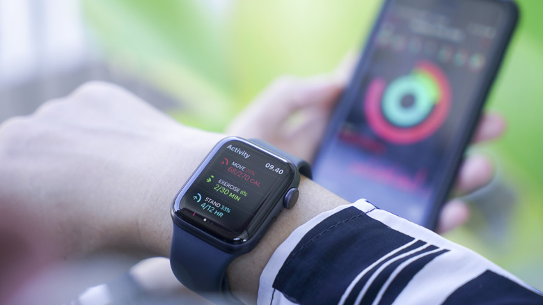 A person checking their activity on both an Apple Watch and iPhone
