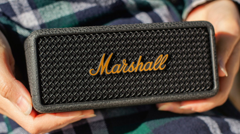 Person holding a Marshall portable speaker