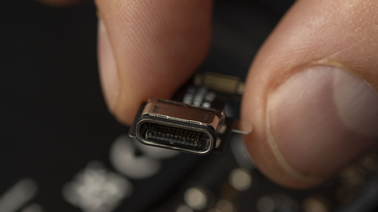 Fingers holding a USB port.
