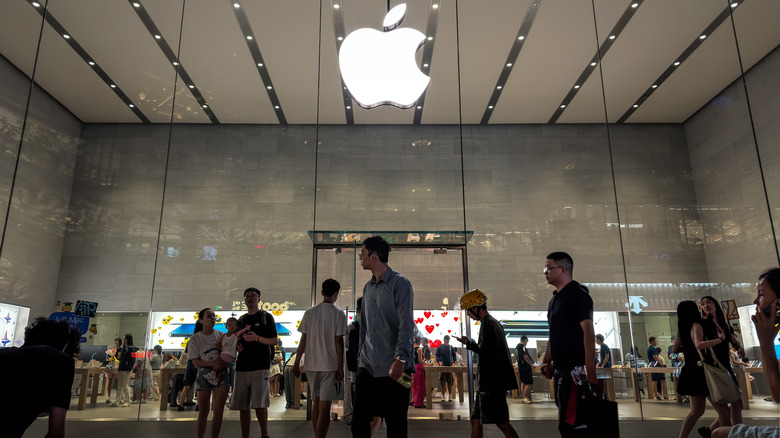 People walking by an Apple retail store.