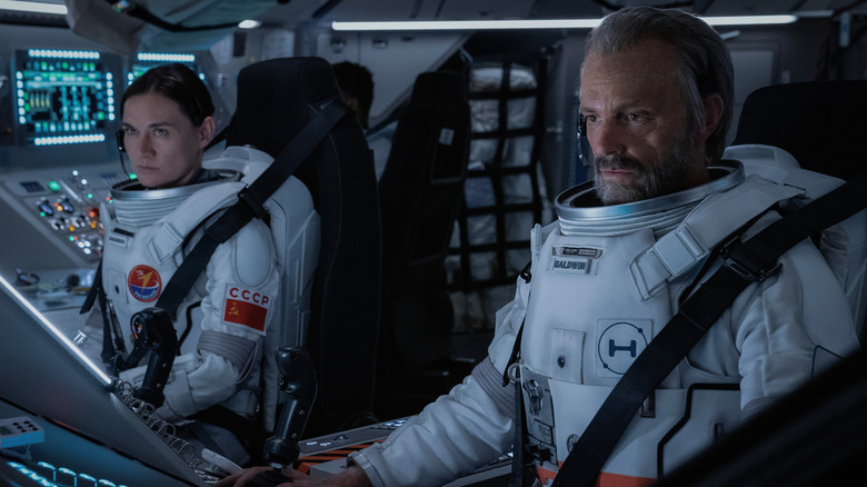 "For All Mankind" characters Svetlana Zakharova (Masha Mashkova) and Ed Baldwin (Joel Kinnaman) sitting in the cockpit of a space shuttle