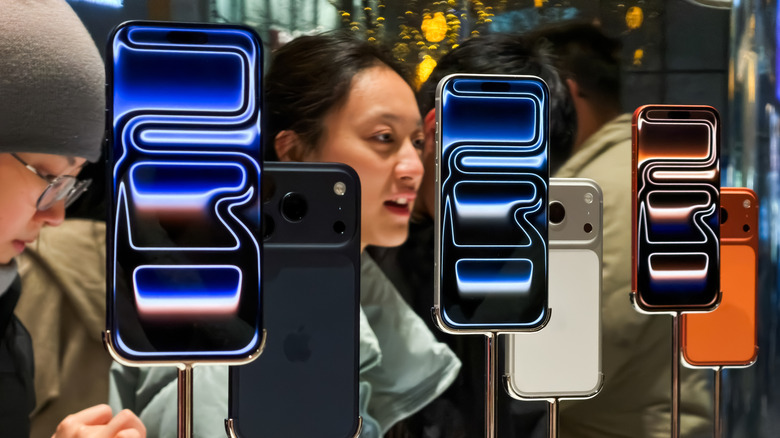 The iPhone 17 on display in a store with people in the background