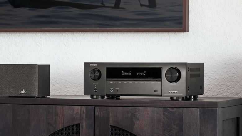 Denon AV receiver on shelf below TV.
