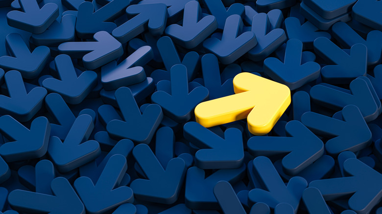 A collection of 3D black arrow icons with a yellow arrow on top.