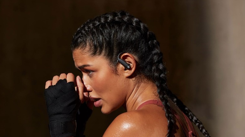 A woman wearing the Beats Powerbeats Pro 2 Wireless Earbuds while working out.
