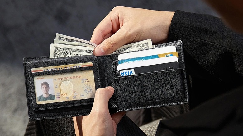 A person pulling bills from the ESR Geo Wallet