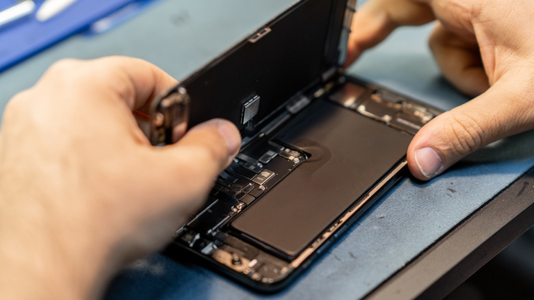 close up on a person taking the back off a smartphone to reveal the battery pack