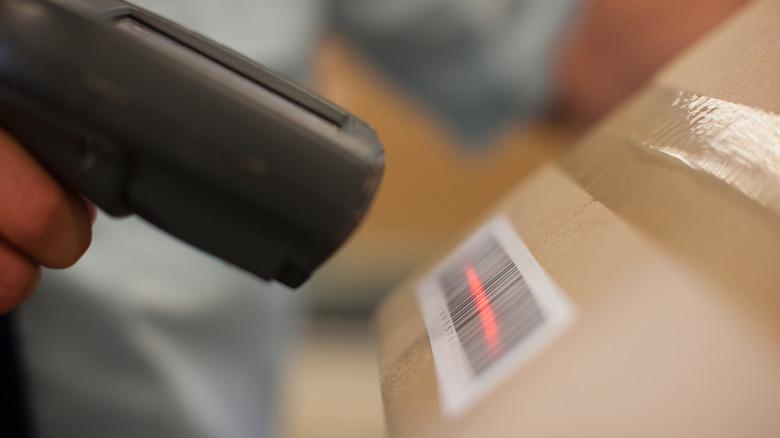 A barcode scanner reads a barcode stuck on a box.