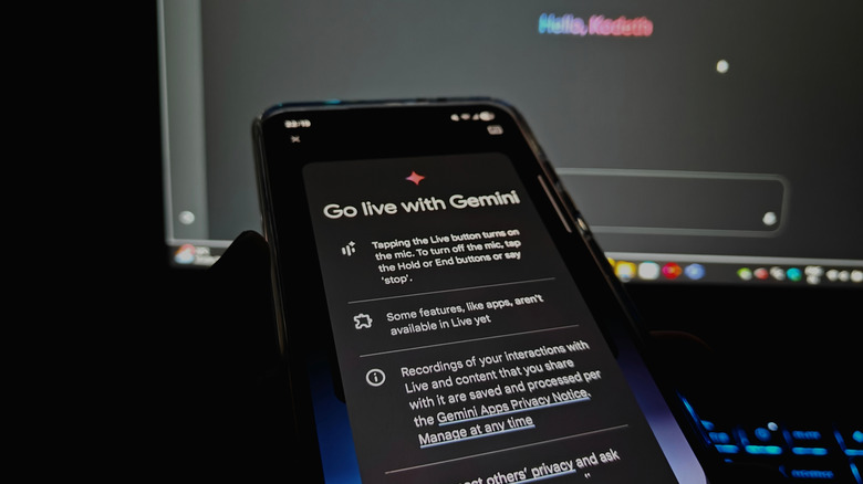 Go live screen in Google Gemini on a smartphone in front of a computer monitor