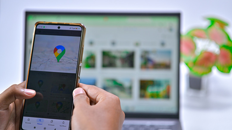 person holding smartphone with google maps