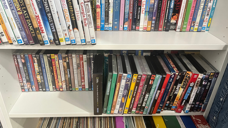 A shelf in a house with a bunch of movies